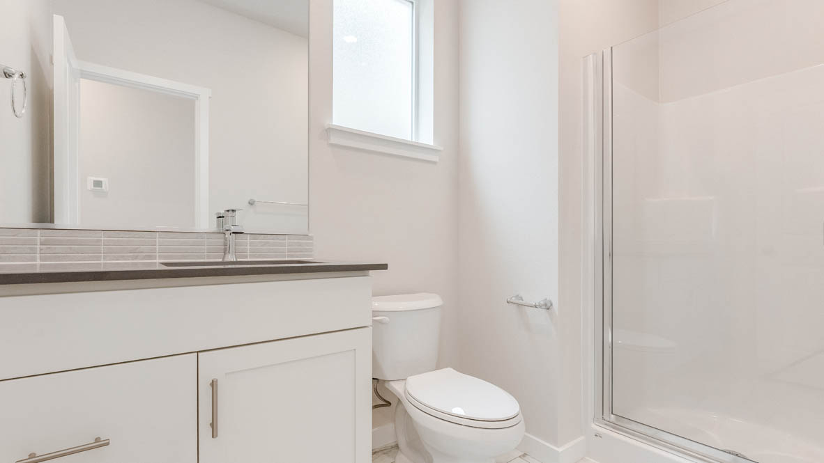 Gordon Creek Pointe with quartz countertops, toilet, window, and mirror