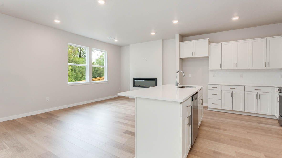 Gordon Creek Pointe Great room and Kitchen with island, quartz countertops, white shaker cabinets, and stainless steel appliances