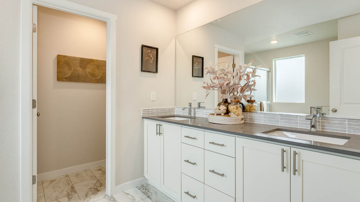 Gordon Creek Pointe primary bathroom with white shaker style cabinets and gray countertops