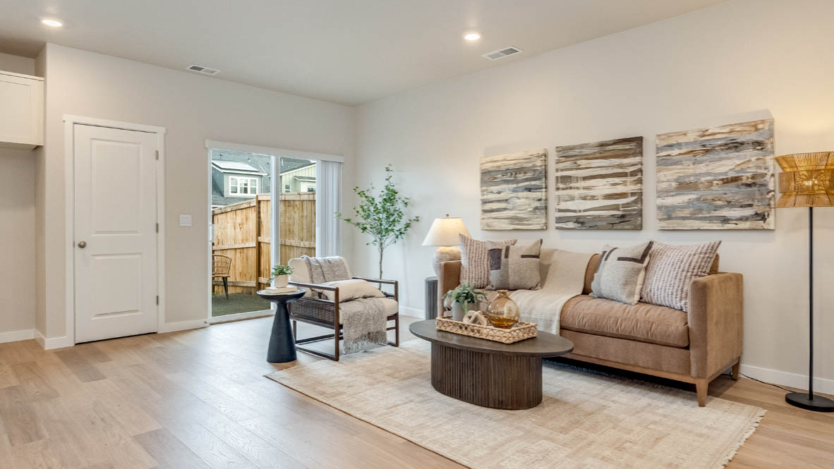 Gordon Creek Pointe great room with a couch, lamp, chair, paintings, coffee table, fireplace and laminate flooring