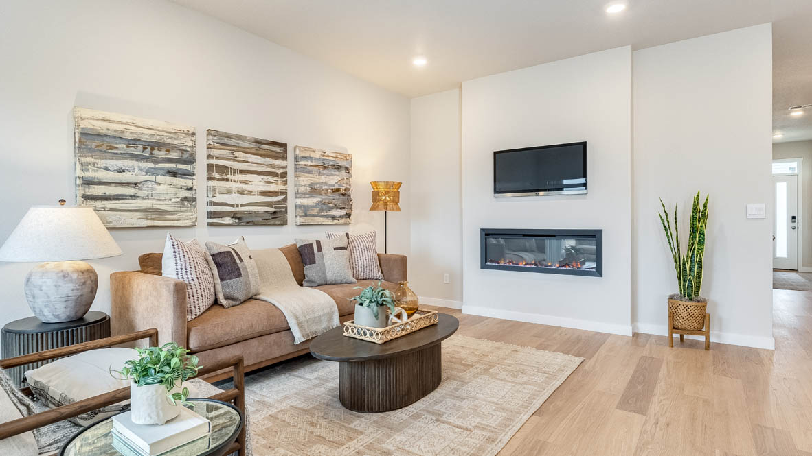 Gordon Creek Pointe great room with a couch, lamp, chair, paintings, coffee table, fireplace and laminate flooring