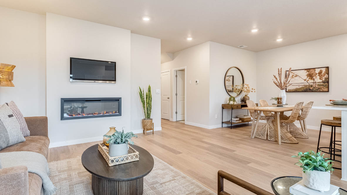 Gordon Creek Pointe great room with a couch, lamp, chair, paintings, coffee table, fireplace and laminate flooring