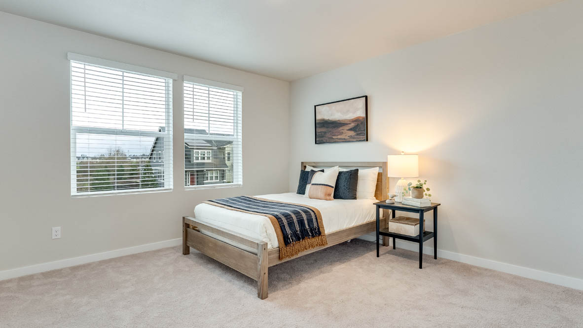 Gordon Creek Pointe bedroom with carpeting and two windows and white walls, a bed, and three paintings