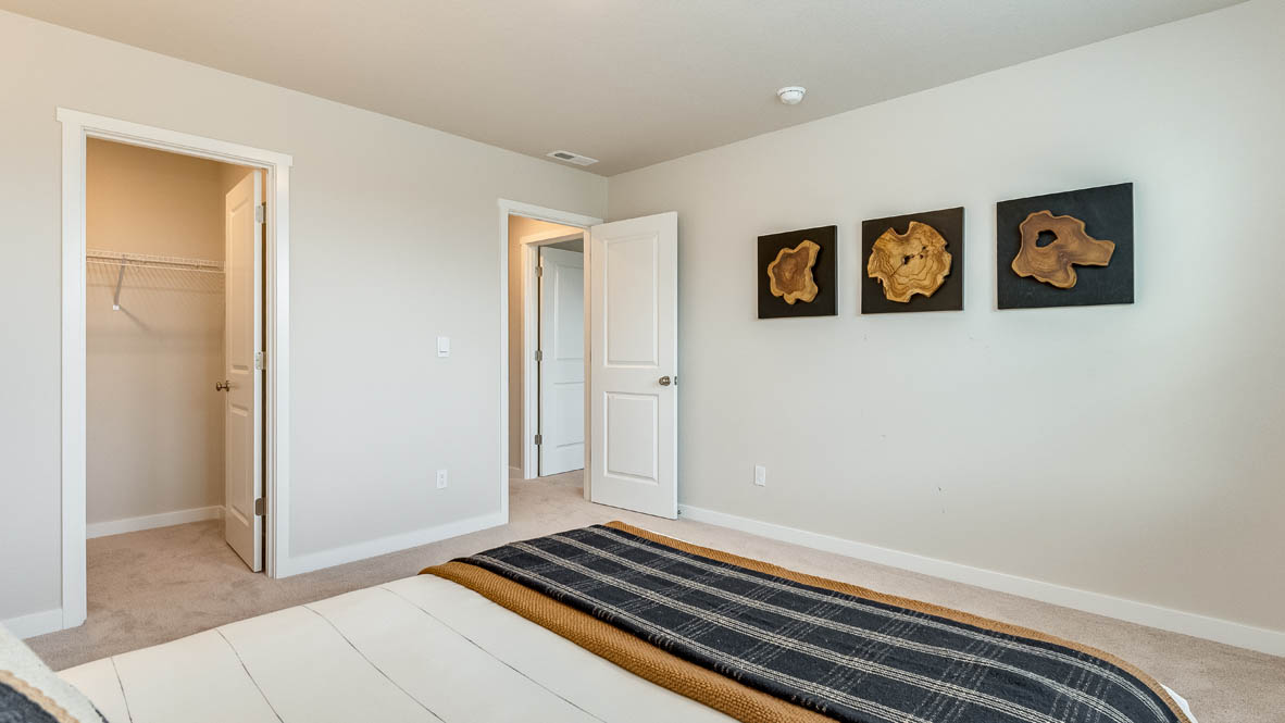Gordon Creek Pointe bedroom with carpeting and two windows and white walls, a bed, and three paintings