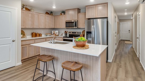 Blue Pearl Kitchen with light wood cabinets and stainless steel appliances