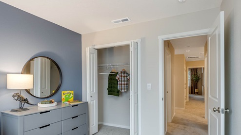 Blue Pearl Bedroom with blue accent wall and dinosaur theme with twin bed, dresser, and a round mirror