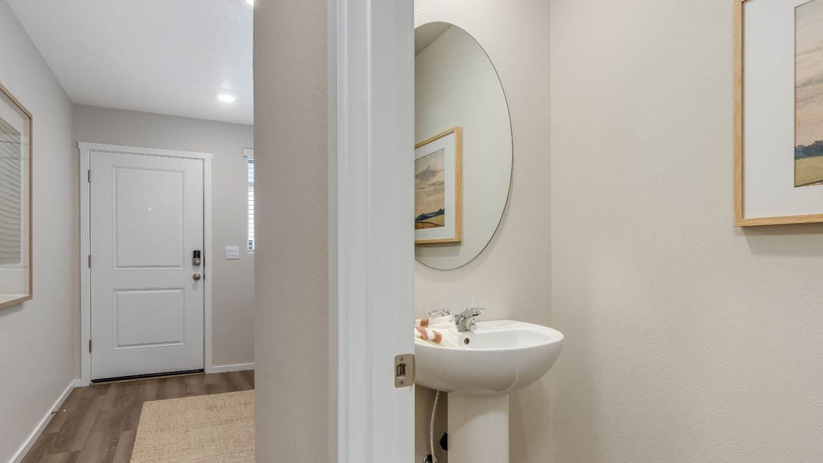 Blue Pearl powder room with pedestal sink and round mirror