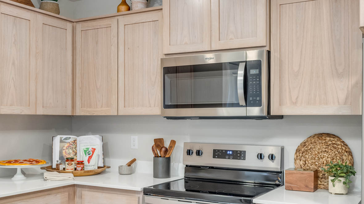 Blue Pearl Kitchen with light wood cabinets and stainless steel appliances