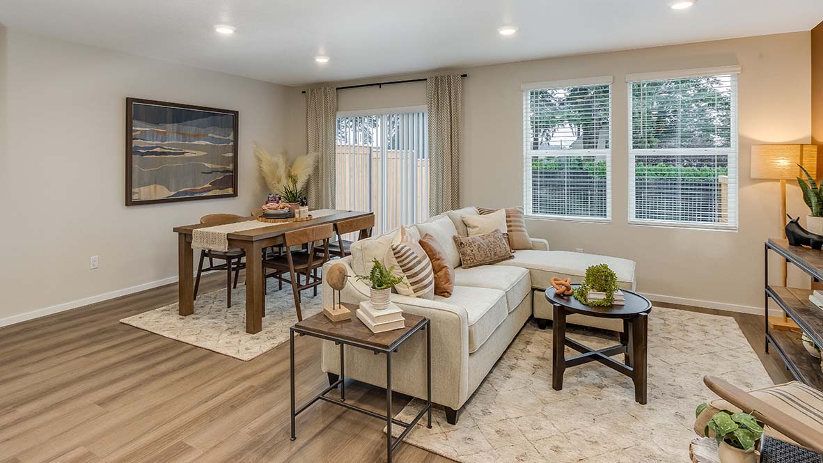 Blue Pearl great room with an L shaped couch, laminate flooring with an area rug, a coffee table and a media console