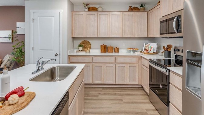 Blue Pearl Kitchen with light wood cabinets and stainless steel appliances