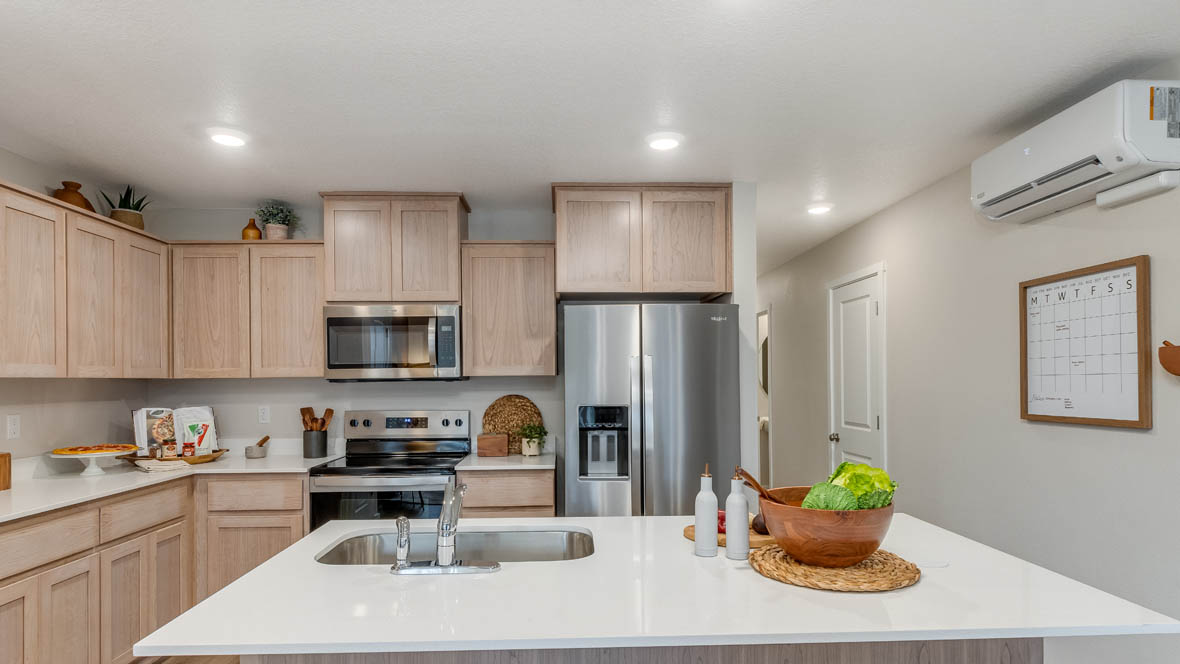 Blue Pearl Kitchen with light wood cabinets and stainless steel appliances