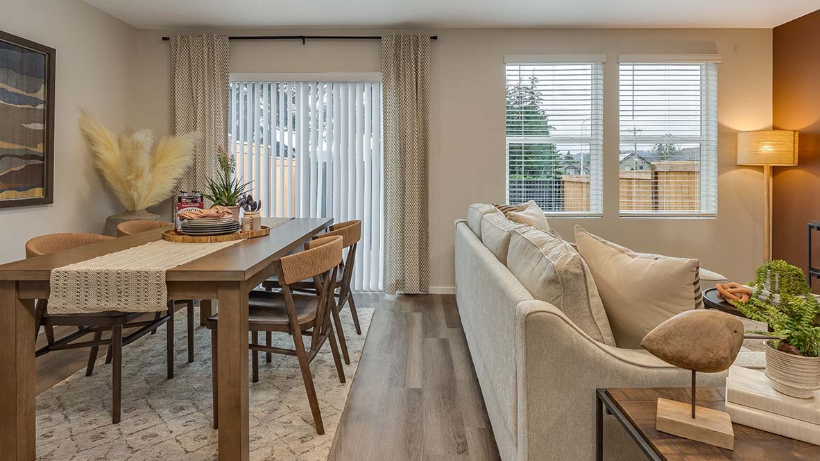 Blue Pearl great room with an L shaped couch, laminate flooring with an area rug, a coffee table and a media console