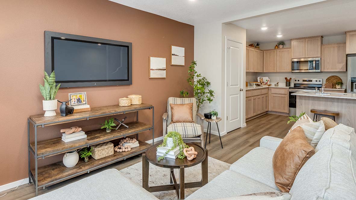 Blue Pearl great room with an L shaped couch, laminate flooring with an area rug, a coffee table and a media console