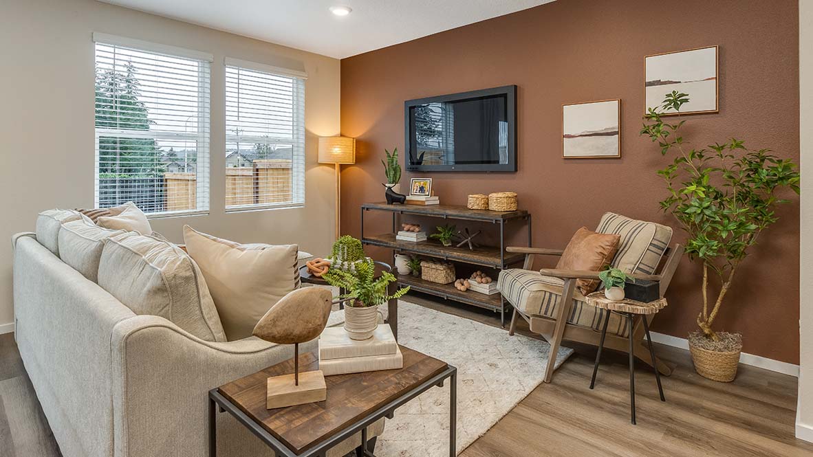 Blue Pearl great room with an L shaped couch, laminate flooring with an area rug, a coffee table and a media console