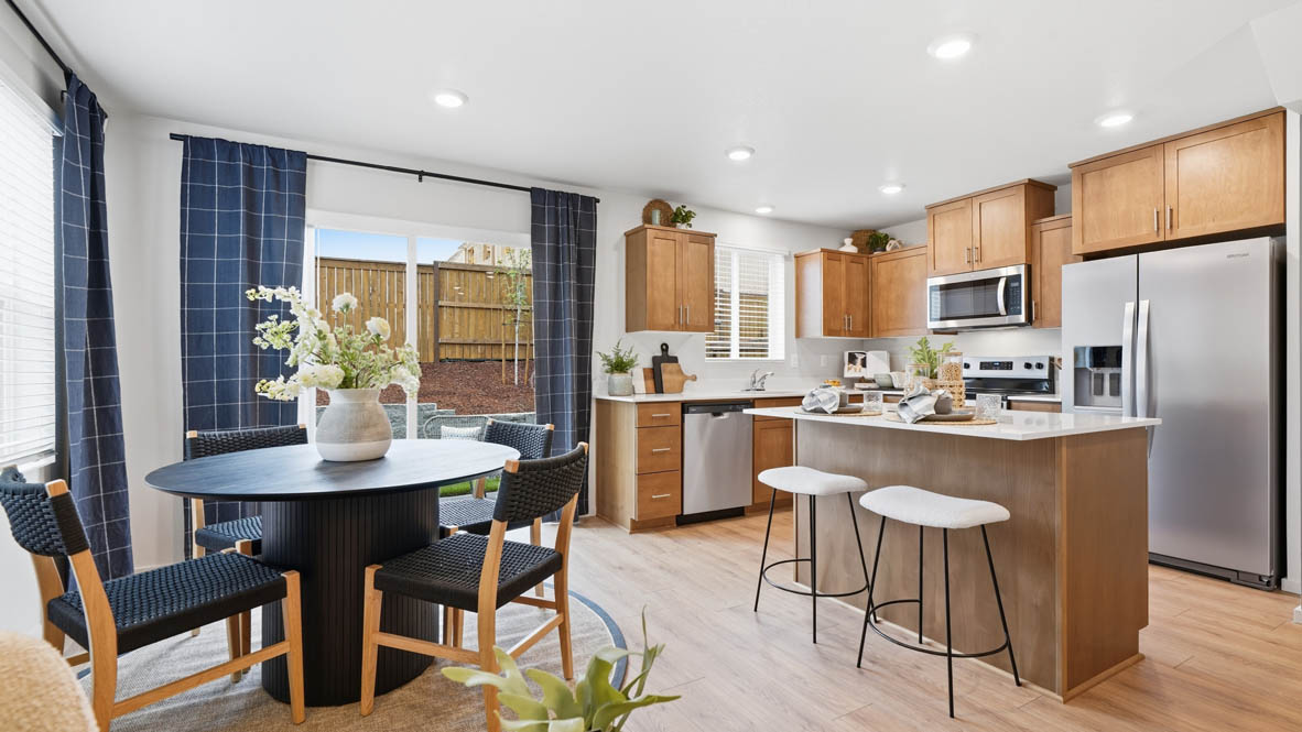 Kitchen with shaker cabinets, quartz counters, stainless steel appliances, pantry, and an island with a breakfast bar