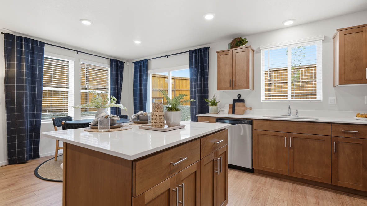 Kitchen with shaker cabinets, quartz counters, stainless steel appliances, pantry, and an island with a breakfast bar