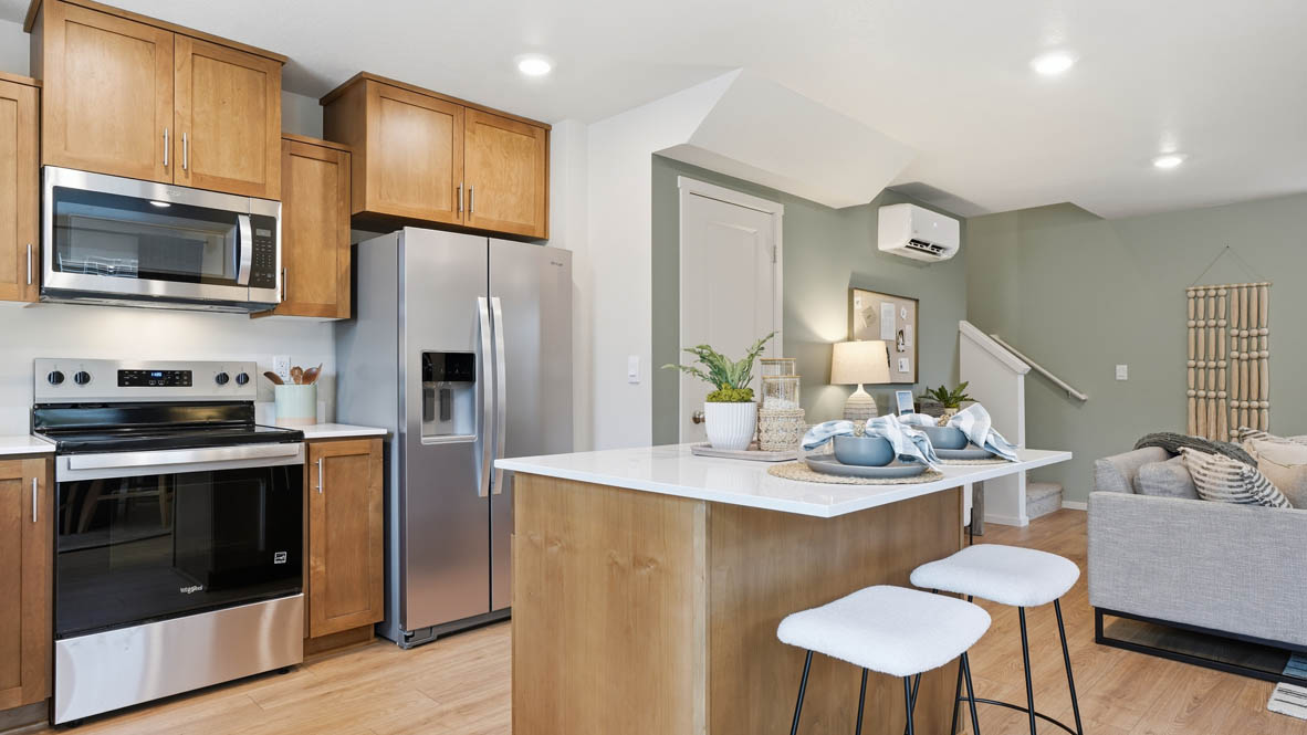 Kitchen with shaker cabinets, quartz counters, stainless steel appliances, pantry, and an island with a breakfast bar