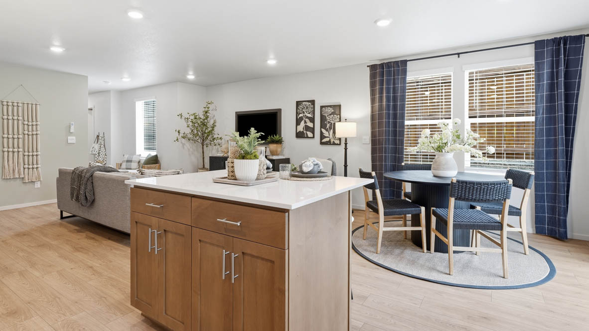 Kitchen with shaker cabinets, quartz counters, stainless steel appliances, pantry, and an island with a breakfast bar