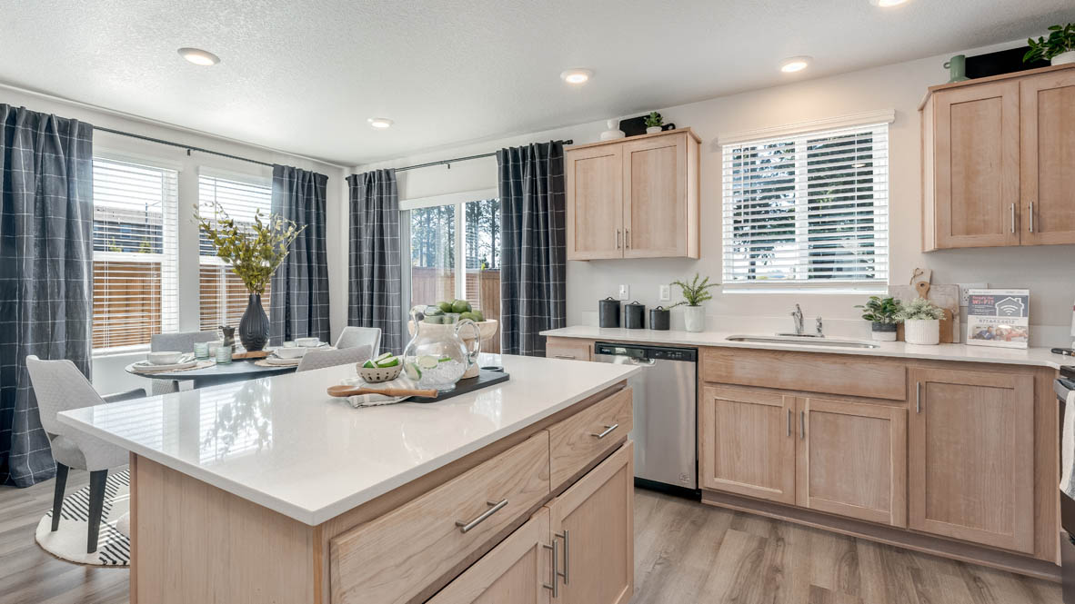 Blue Pearl kitchen with island, stainless steel appliances, dining table, quartz countertops, a cabinets