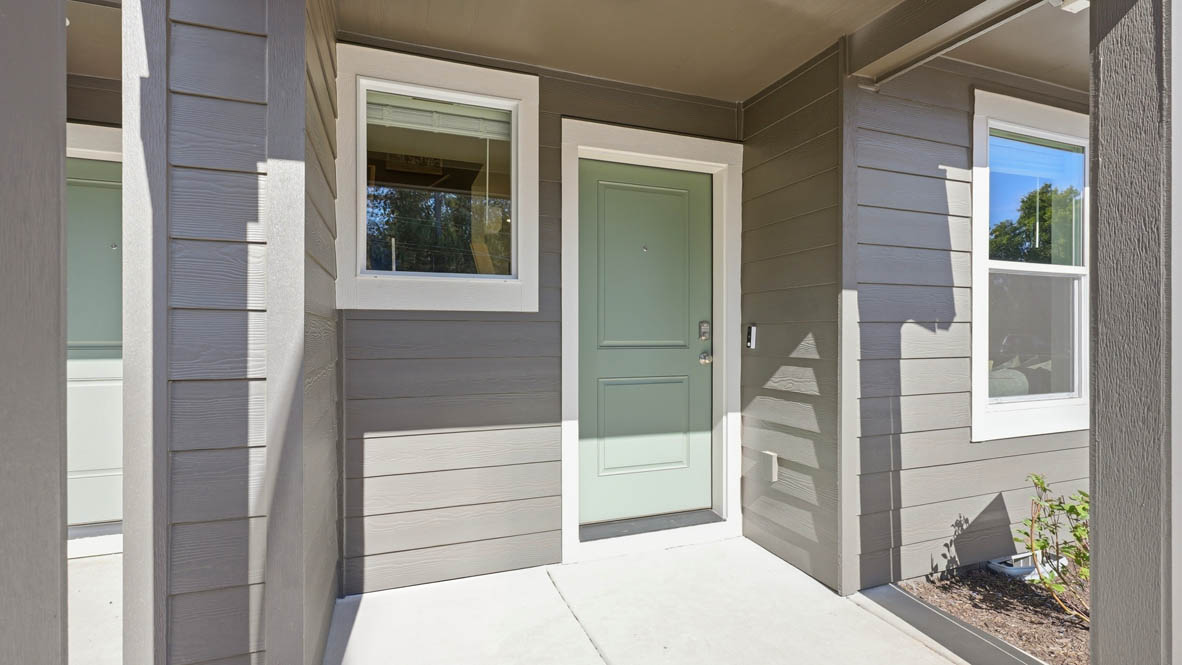 Thunder Ridge Forest Plan front door with a green accent and white trim, and gray paint