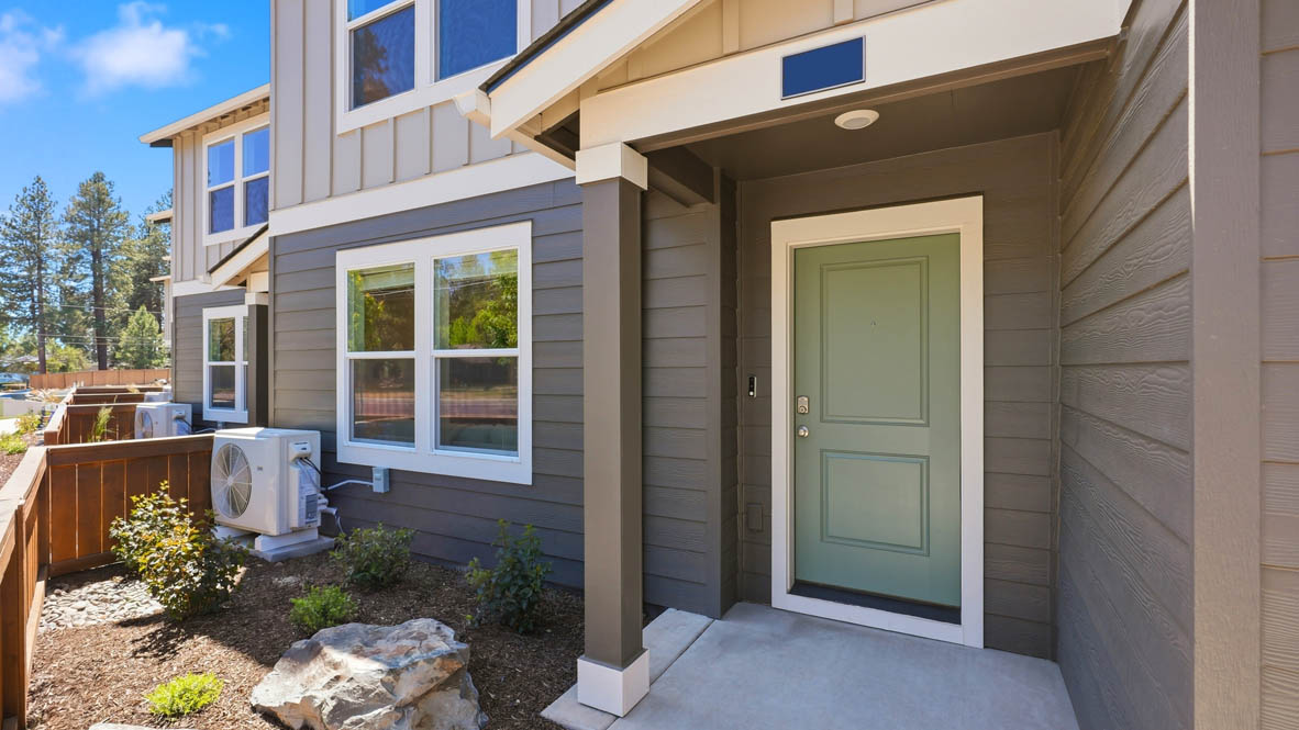 Thunder Ridge woodbridge Plan front door with a green accent and white trim, and gray paint