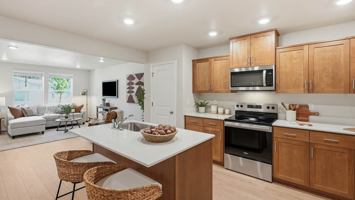 Thunder Ridge kitchen with stained shaker style cabinets and brushed nickel pulls with solid surface countertops and stainless steel appliances