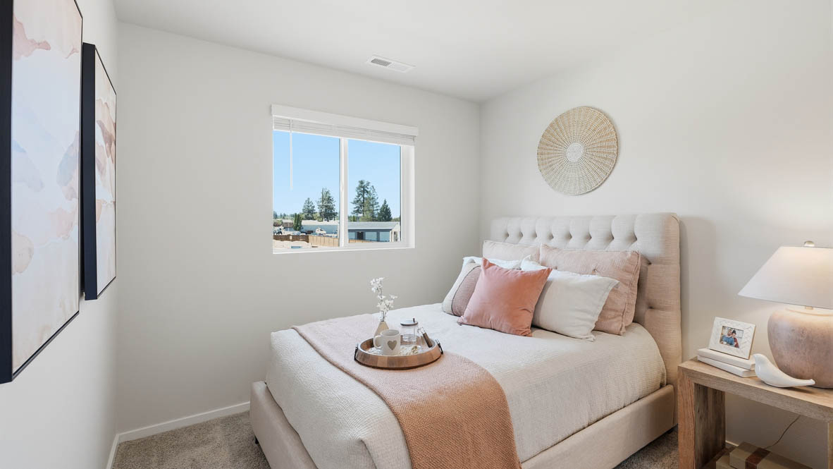 Thunder Ridge bedroom staged as a nursery room, pink accents, carpet, a wooden chair, and a nursery bed