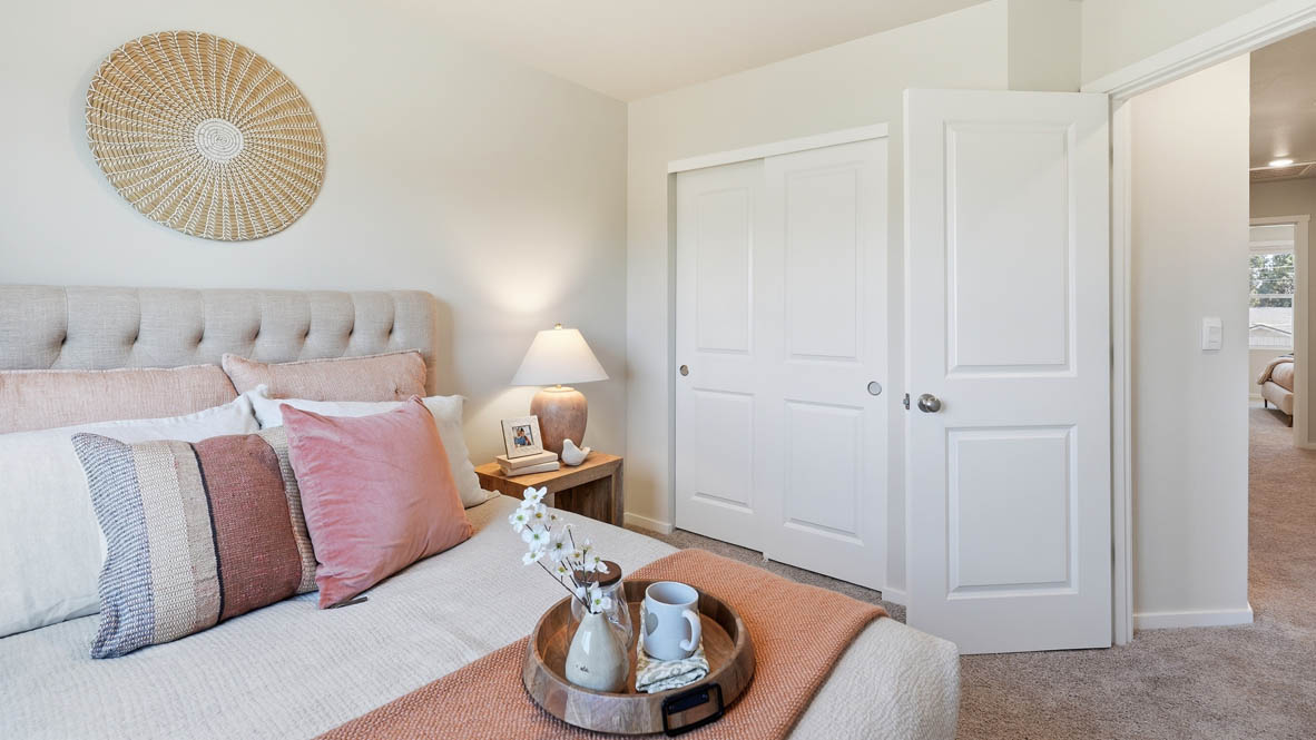 Thunder Ridge bedroom staged as a nursery room, pink accents, carpet, a wooden chair, and a nursery bed
