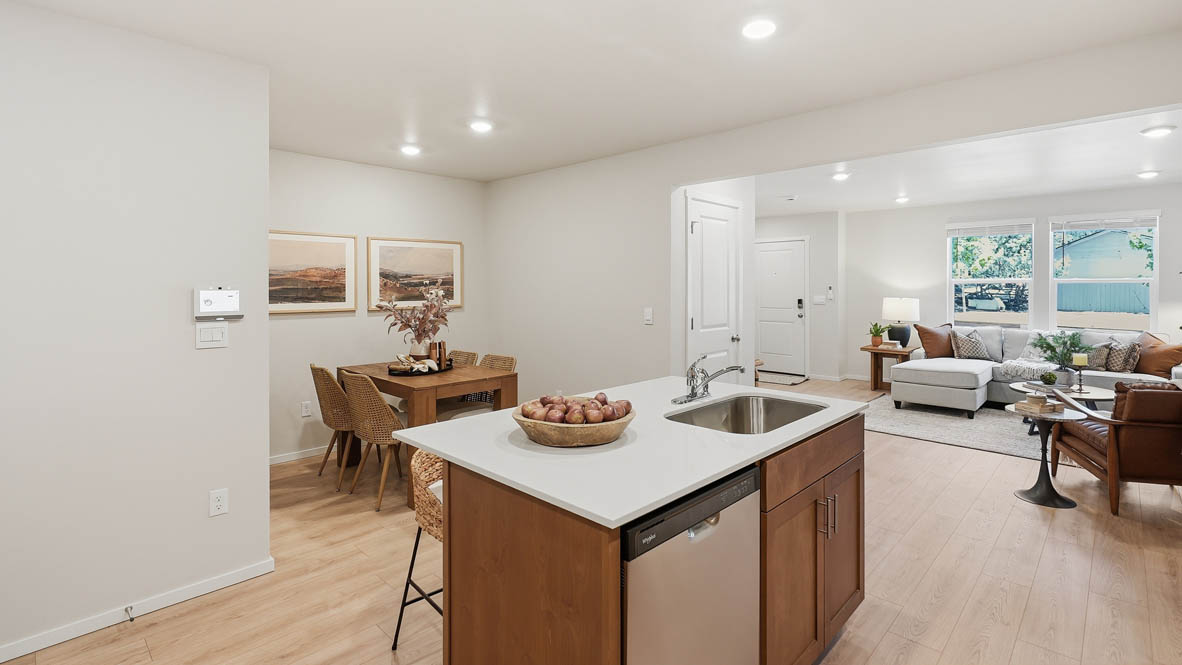 Thunder Ridge kitchen with stained shaker style cabinets and brushed nickel pulls with solid surface countertops and stainless steel appliances