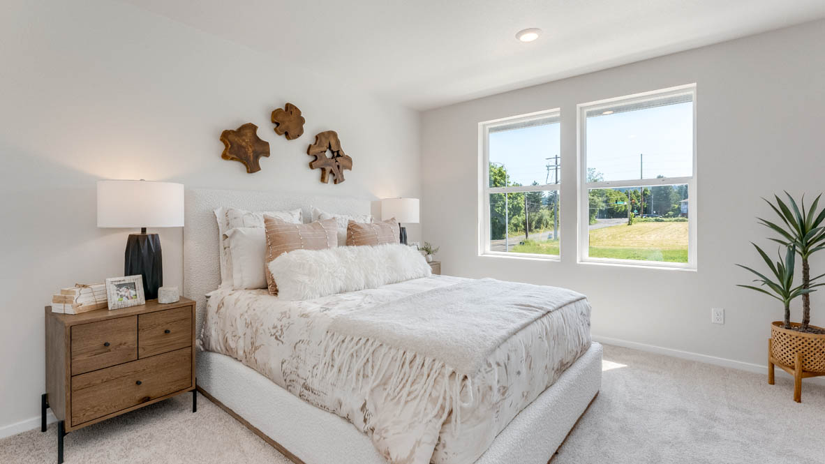 Thunder Ridge Primary Bedroom with carpet, a bed with gray bedding, brown nightstands with lamps, and windows