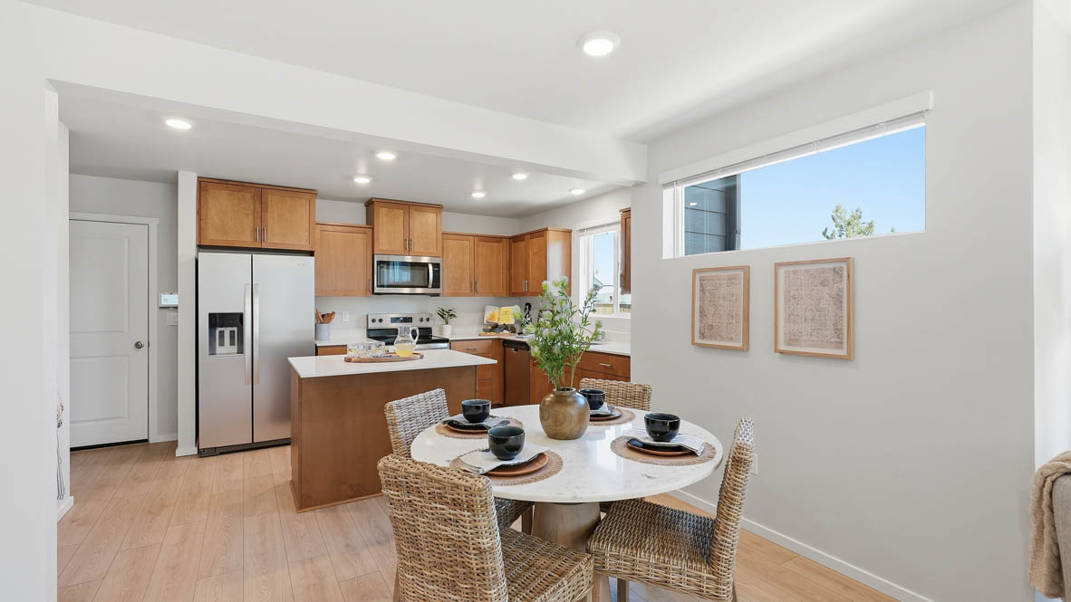 Thunder Ridge dining room with wooden table and chairs set for four next to the kitchen