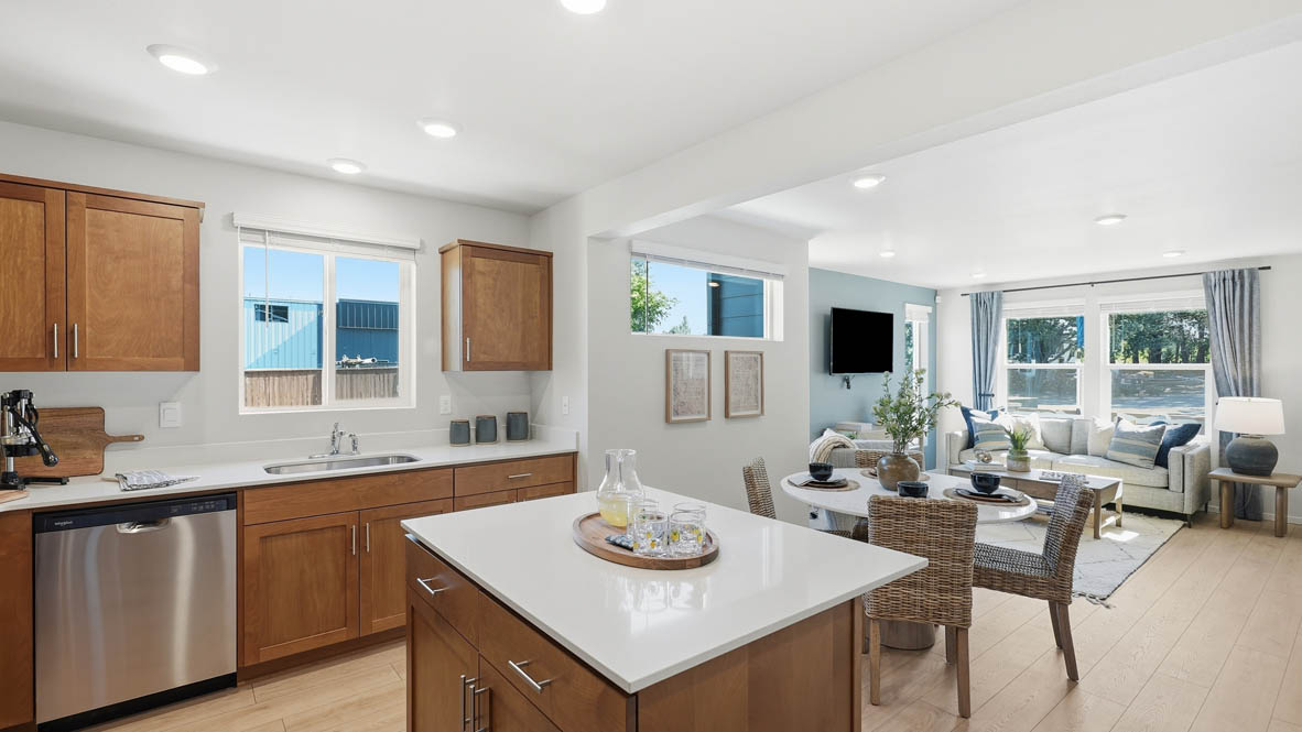 Thunder Ridge kitchen with stained shaker style cabinets and brushed nickel pulls with solid surface countertops and stainless steel appliances