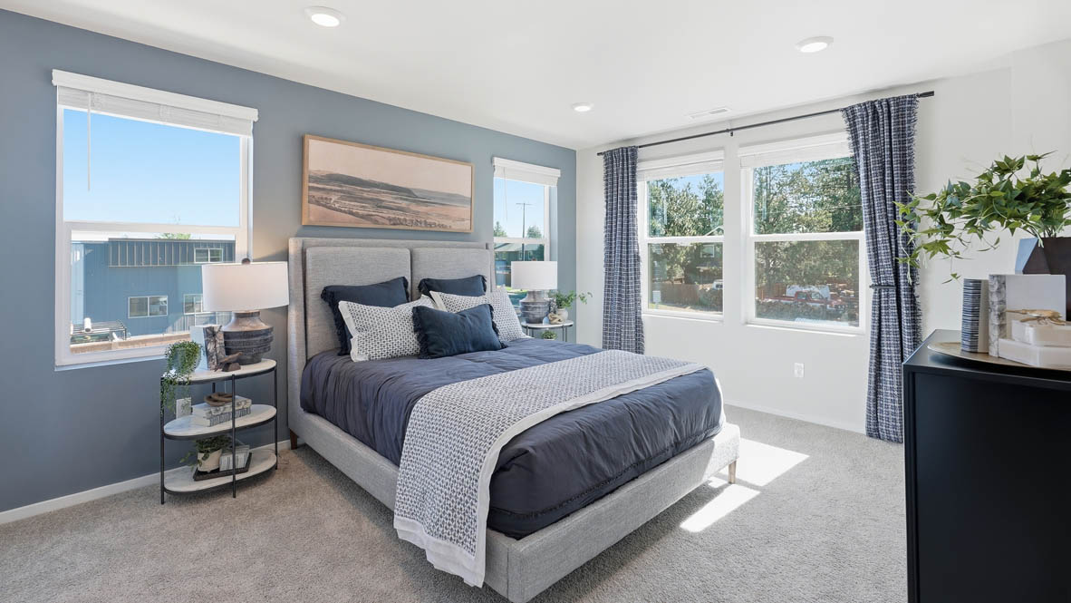 Thunder Ridge Primary Bedroom with carpet, a bed with blue bedding, nightstands with lamps, and windows