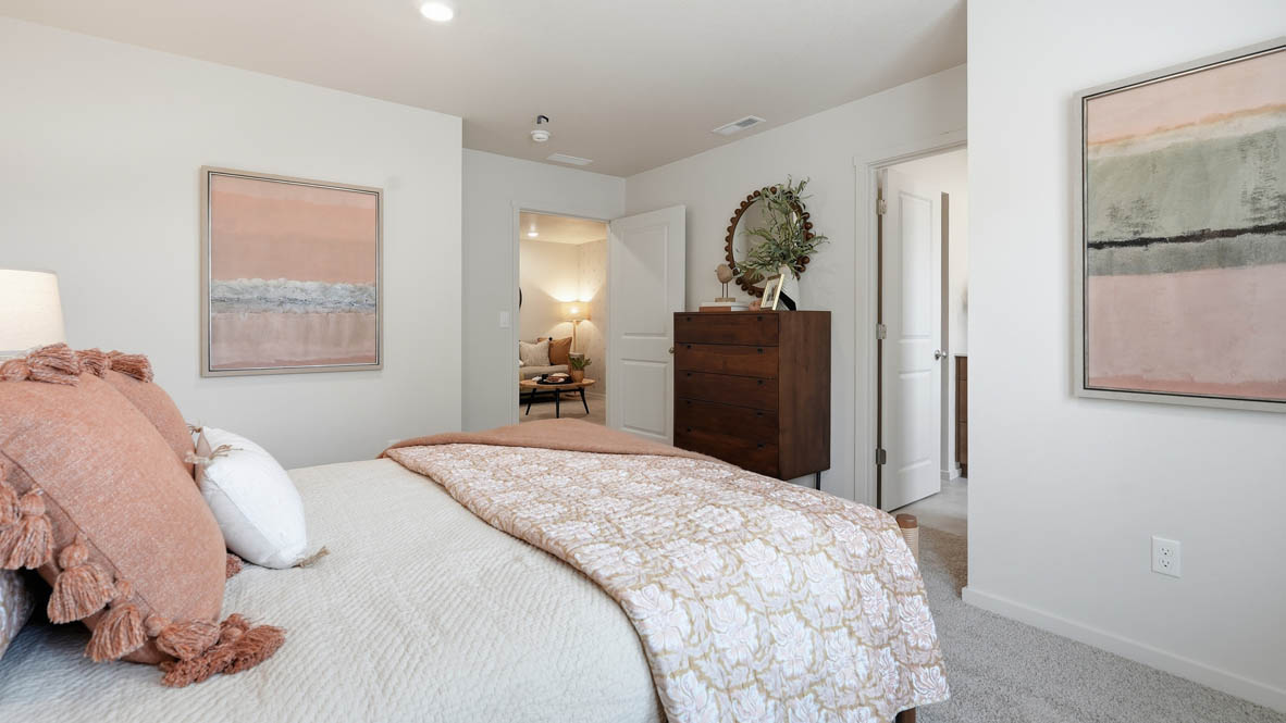 Thunder Ridge primary bedroom with white walls, carpet and wood furniture