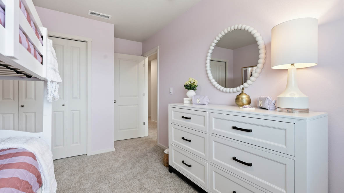 Thunder Ridge bedroom with pink walls, white furniture, and carpet