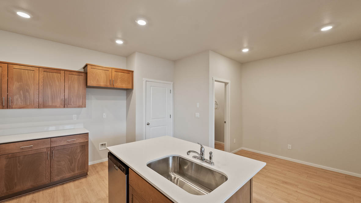 Ponderosa kitchen with stained shaker style cabinets and brushed nickel pulls with solid surface countertops and stainless steel appliances