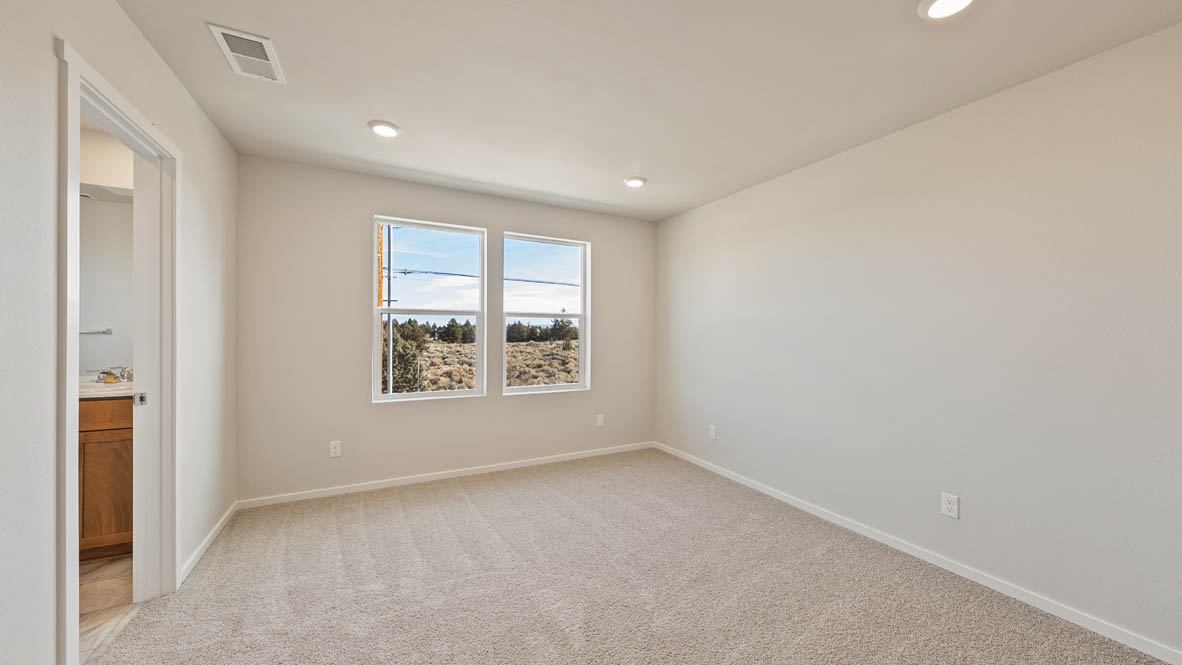 Ponderosa primary bedroom with carpeting and white walls and windows