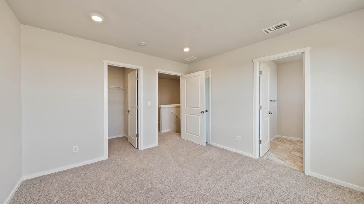 Ponderosa primary bedroom with carpeting and white walls and windows