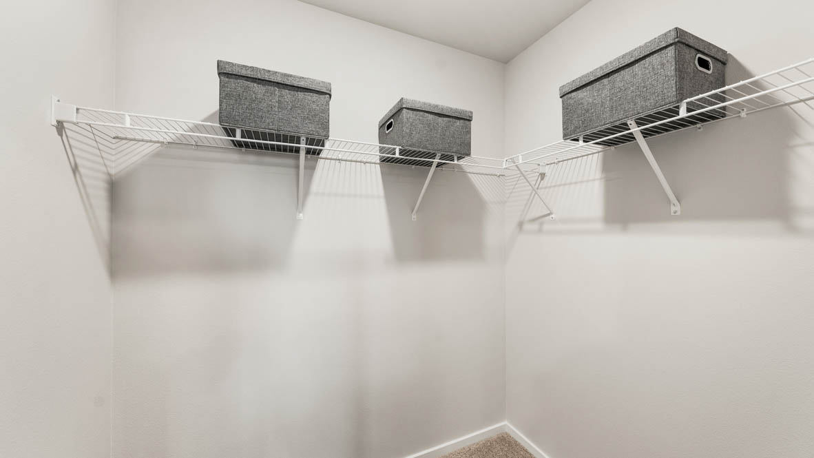 Ponderosa walk in closet with white wire shelving and baskets on the shelves