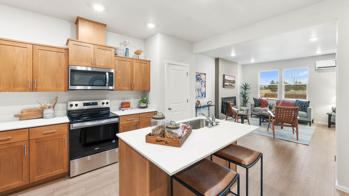 Ponderosa kitchen with stained shaker style cabinets and brushed nickel pulls with solid surface countertops and stainless steel appliances