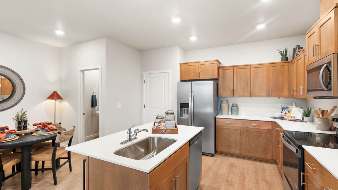 Ponderosa kitchen with stained shaker style cabinets and brushed nickel pulls with solid surface countertops and stainless steel appliances