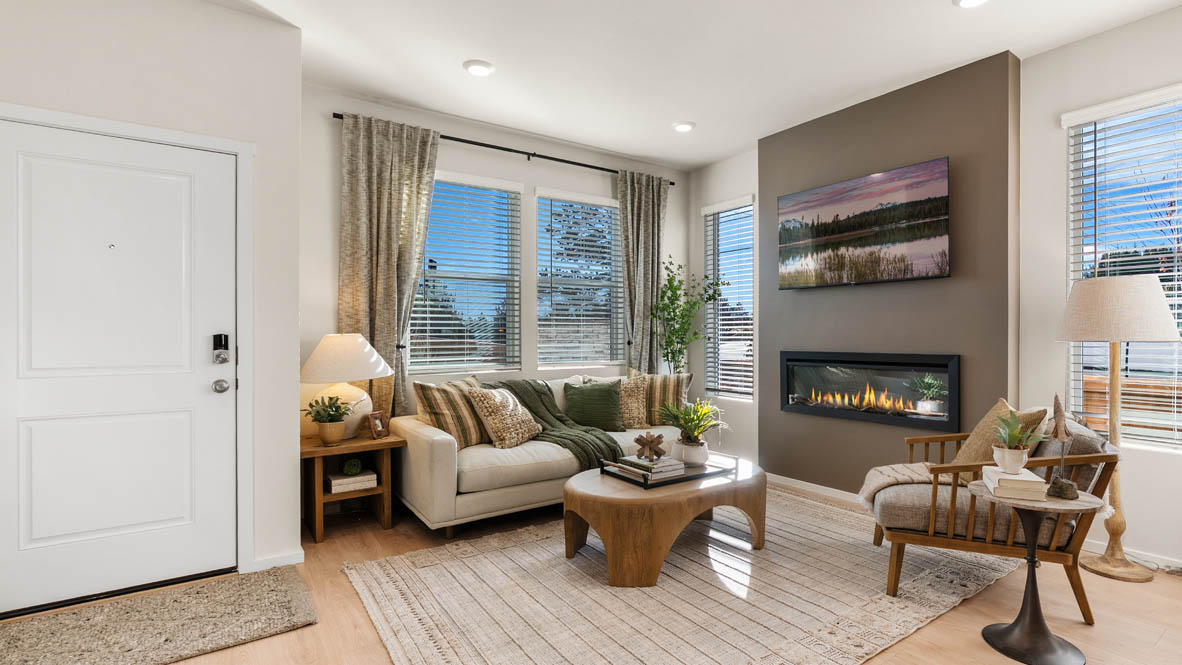 Ponderosa great room with laminate floors and couch and coffee table on area rug next to lit fireplace