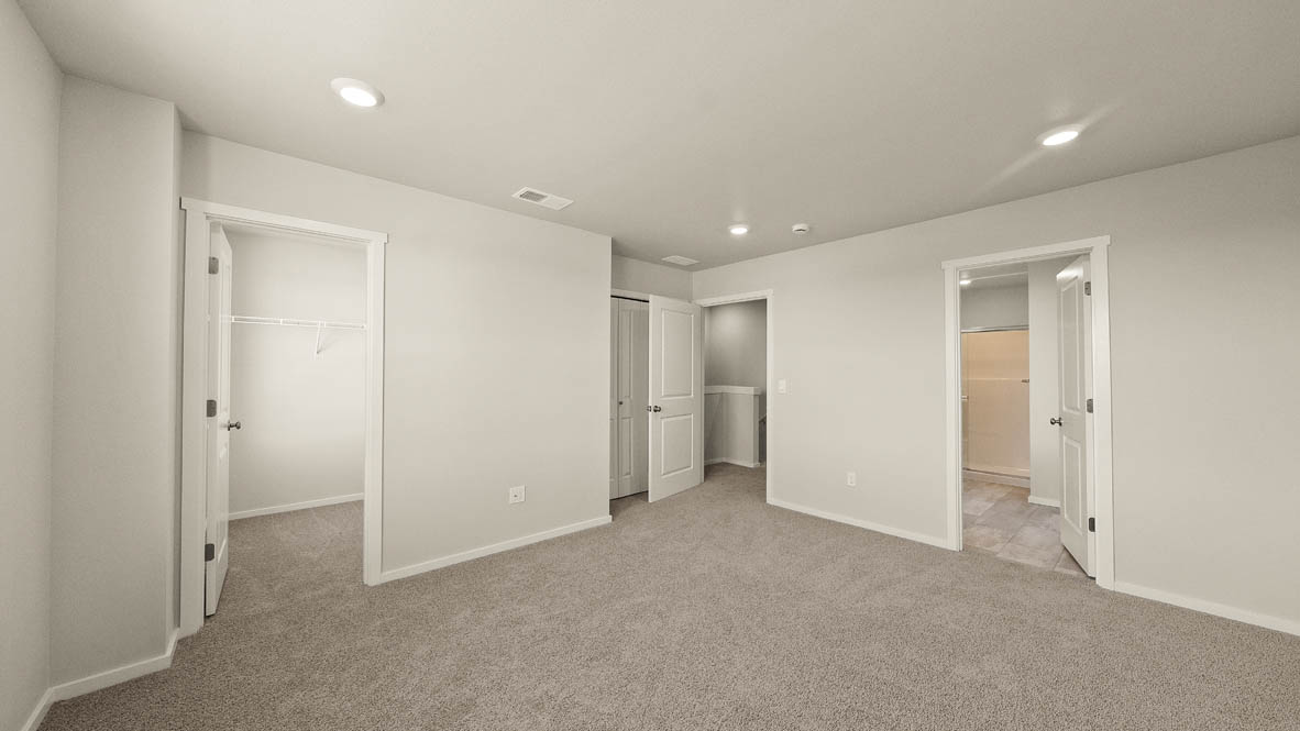 Ponderosa primary bedroom with carpeting and white walls and windows