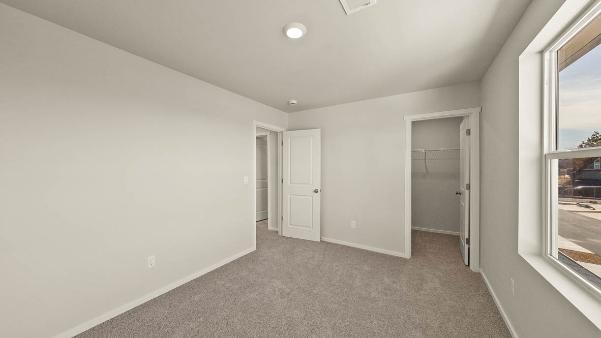 Ponderosa bedroom with carpeting and white walls and windows