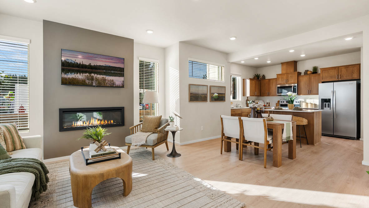 Ponderosa Great room with a white couch and pillows, chair, wood coffee table, laminate flooring, a lamp, electric fireplace and windows
