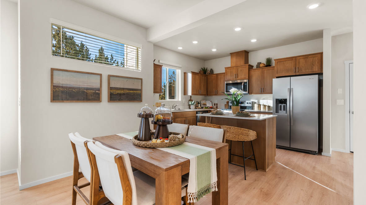 Ponderosa dining room with wooden table and chairs set for four next to the kitchen