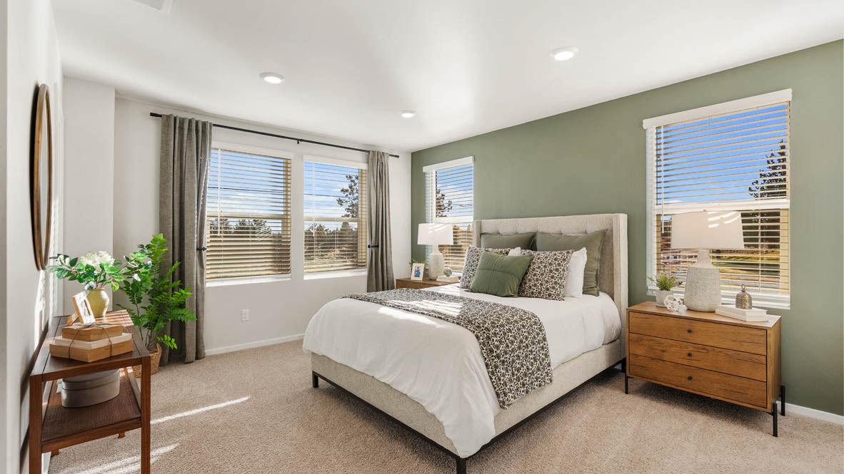 Ponderosa Primary Bedroom with carpet, a bed with gray bedding, brown nightstands with lamps, and windows