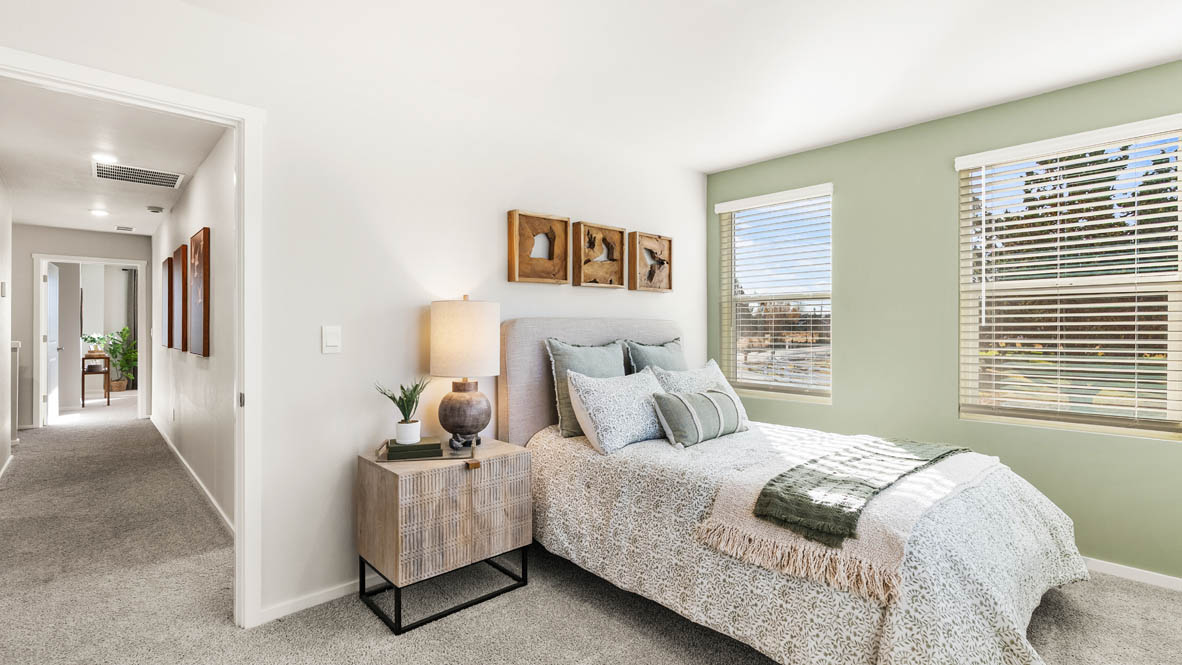 Ponderosa bedroom with green and wooden accents with carpeting and a window