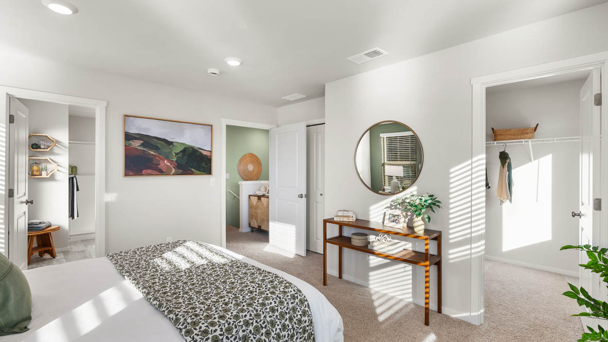 Ponderosa primary bedroom with carpet and with green accent wall and wooden side tables