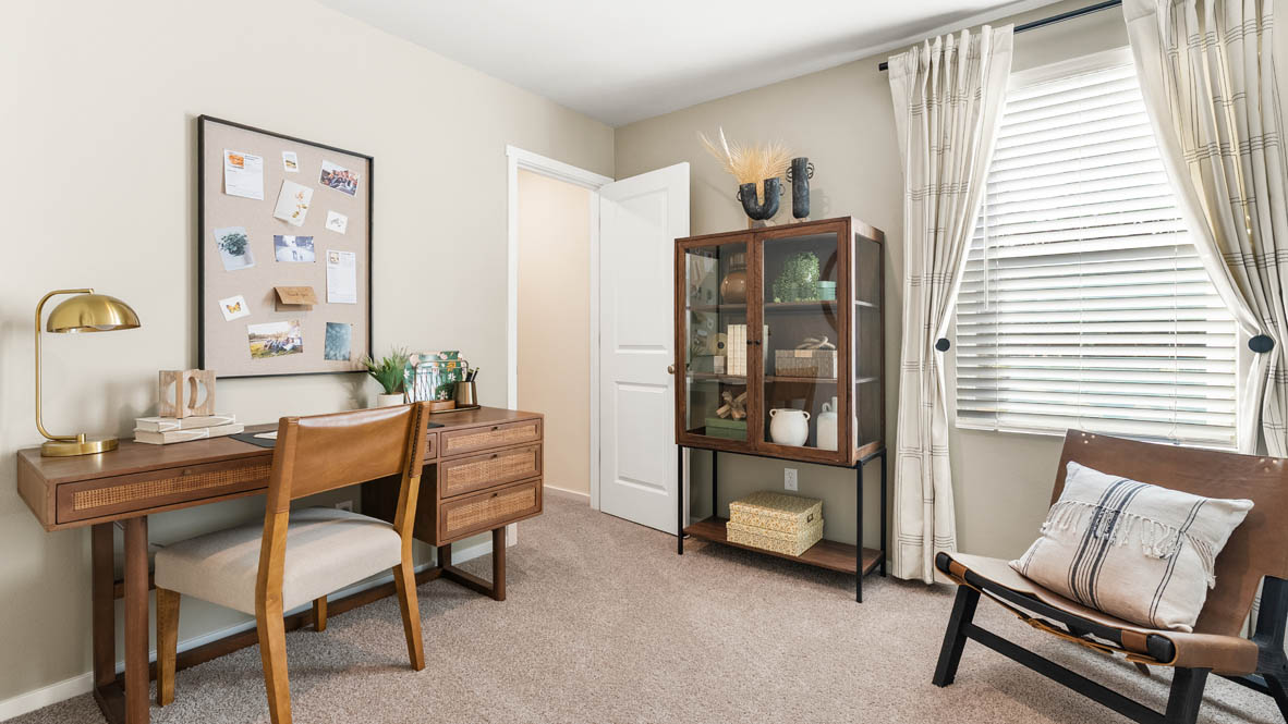 Ponderosa bedroom staged as an office with wooden furniture and wall hangings